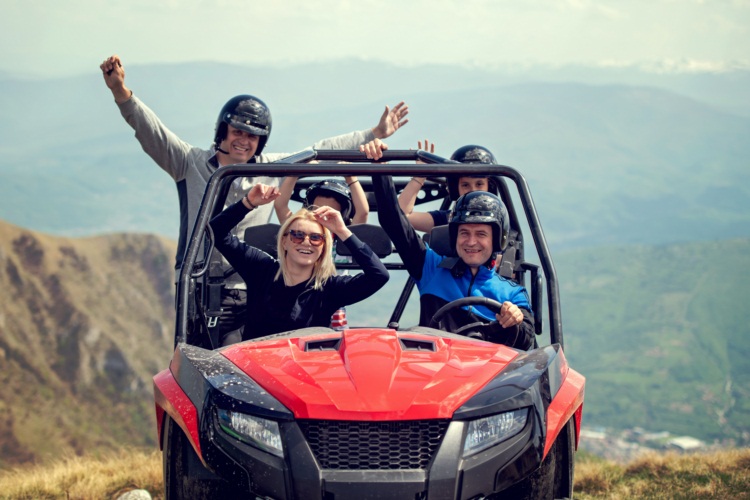 Friends driving off-road with quad bike or ATV and UTV vehicles