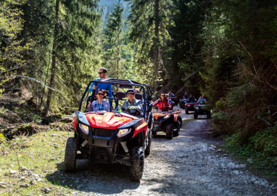 A tour group travels on ATVs and UTVs on the mountains